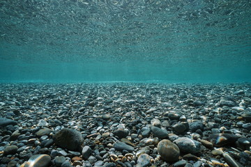Pebbles rocks underwater below sea surface in shallow water, natural scene, Mediterranean, France