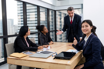 Beautiful Asian businesswoman thumb up with colleague in office or workplace meeting room. Success team work concept