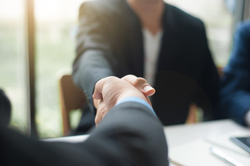 Business people shake hands while the meeting is completed and successful.