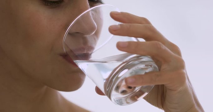 Healthy young woman holding glass drinking water keep hydration balance