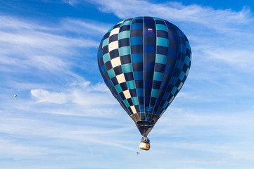 Hot air a balloon with a scorched  envelope against a blue sky