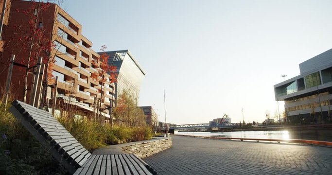 4K low angle wide shot with backward slide motion of Lambda, the new Edvard Munch museum, with famous paintings like Evening on Karl Johan, in an autumn sunset in the Bj&oslash;rvika quarter in Oslo, Norway.