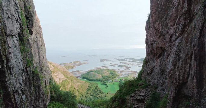 4K wide drone shot with forward motion of the scenic ocean view from a natural glacial made tunnel through the popular mountain and tourist attraction Torghatten, in Br&oslash;nn&oslash;ysund Helgeland Norway.