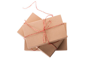 Christmas, New Year stacked gift boxes, parcel, present packed in eco-friendly paper tied with rope, with red and golden baubles with shadow isolated on white background top view
