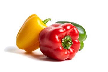 Red, green, and yellow bell peppers isolated on white background. Sweet peppers in different colors, vegetable ingredient, healthy food