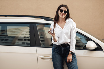 Close Up Portrait of One Stylish Young Female Dressed in Jeans and White Shirt Holds Keys to Her New Car, Business Lady, Woman Power Concept