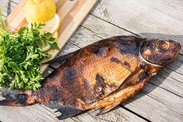fish with lemon and greens on grey wooden boards