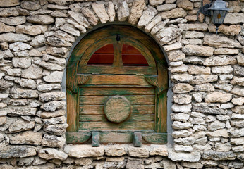 Old wooden window in a stone wall.