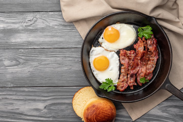 Fried eggs with bacon in a pan. Top view.