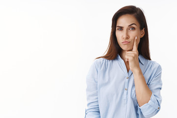 Sly charismatic thoughtful middle-aged 30s woman, smirk look cunning and intrigued camera, touch cheek, pull thoughtful interested face squinting suspicious, thinking white background