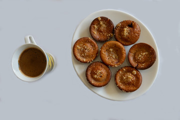 Coffee and homemade tasty muffins on a plate, served for the unhealthy desire in the brunch. Blackberry sponge cupcake product with espresso cafe.