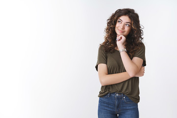 Charming dreamy cute armenian girl with curly hair look up touch chin smiling silly recall nice...