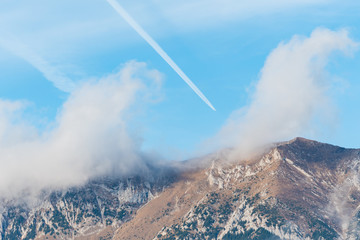 A Plane Heading Towards the Cloudy Mountain a a Sunny Autumn Day