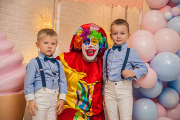 Obraz na płótnie Canvas Clown boy from the circus at the birthday party. Little brothers and a clown. Party for children.