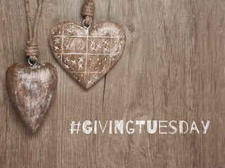 Givingtuesday is a global charity campaign - Black Friday of Charity. Giving Tuesday, global day of charitable giving. Give help, donations and support. Wooden hearts, flat lay on wood with text.