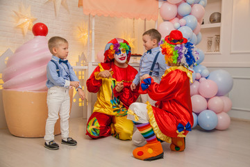 Obraz na płótnie Canvas Circus clowns at the birthday party. Little brothers and clowns. Party for children.