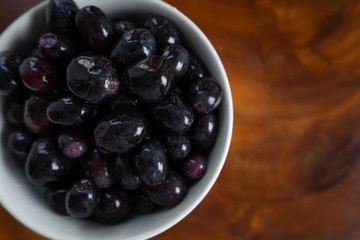Fresh black grapes and leaf on the wooden table.