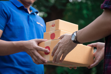 Delivery man holding boxes person who sent the letter to the package box to the recipient to arrive...