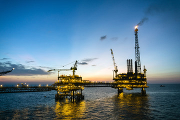 Fototapeta na wymiar Silhouette of oil production platform during sunset