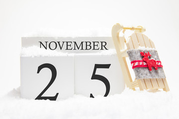 Autumn calendar made of wooden cubes with the date of November 25, the concept of the first snow...