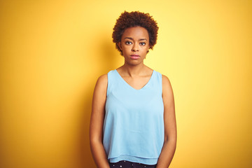 Beautiful african american woman wearing elegant shirt over isolated yellow background Relaxed with...