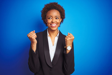 African american business executive woman over isolated blue background celebrating surprised and amazed for success with arms raised and open eyes. Winner concept.