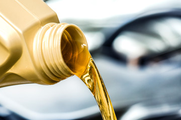 Pour yellow motor oil into car engine. Maintenance service change liquids and fluid.