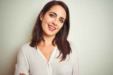 Fototapeta premium Young beautiful woman wearing casual shirt standing over white isolated background happy face smiling with crossed arms looking at the camera. Positive person.