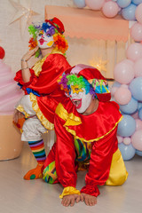 Funny clowns from the circus. Clown boy and clown girl show emotions