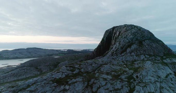 4K wide drone shot with parallax motion of the natural glacial made tunnel through the popular mountain and tourist attraction Torghatten and a panoramic ocean view, in Br&oslash;nn&oslash;ysund Helgeland Norway.