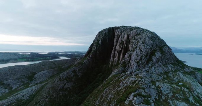 4K wide drone shot with parallax motion of the natural glacial made tunnel through the popular mountain and tourist attraction Torghatten and a panoramic ocean view, in Br&oslash;nn&oslash;ysund Helgeland Norway.