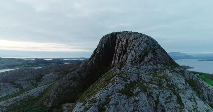 4K wide drone shot with parallax motion of the natural glacial made tunnel through the popular mountain and tourist attraction Torghatten and a panoramic ocean view, in Br&oslash;nn&oslash;ysund Helgeland Norway.
