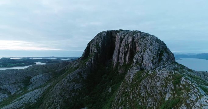 4K wide drone shot with parallax motion of the natural glacial made tunnel through the popular mountain and tourist attraction Torghatten and a panoramic ocean view, in Br&oslash;nn&oslash;ysund Helgeland Norway.