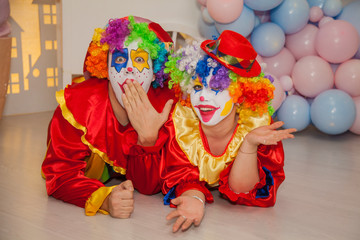 Funny clowns from the circus. Clown boy and clown girl show emotions