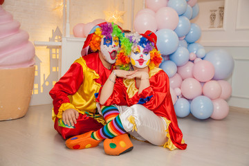 Funny clowns from the circus. Clown boy and clown girl show emotions