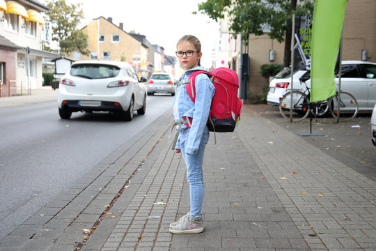 Schulkind m&ouml;chte eine stark befahrene Strasse &uuml;berqueren