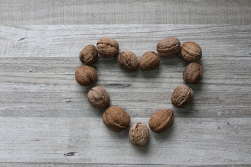 Heart shaped walnuts on wooden background