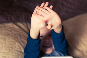 Close-up of boy stretching while waking up in the bedroom.