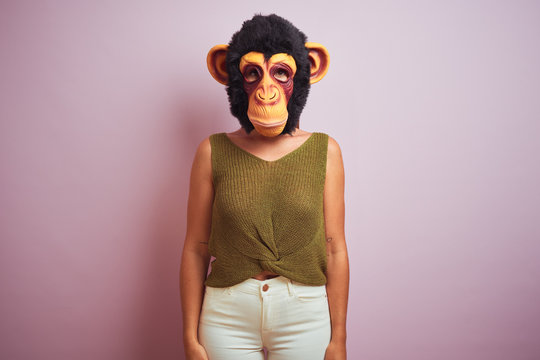Woman standing wearing t-shirt and monkey mask