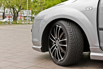 Wheel and rims of a sporty car in gray or silver.