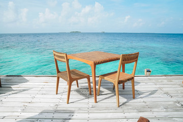 Outdoor terrace with Empty  wooden table and chair with Sea view of Indain ocean, Maldives background