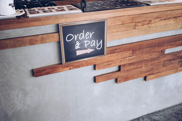 order and pay wooden chalkboard tag on counter bar in cafe or retail shop