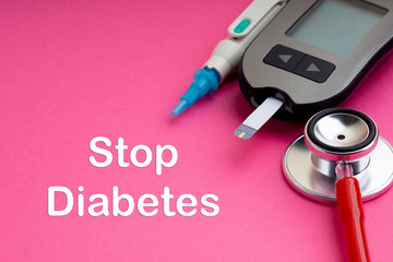 Syringe, Glucometer or Glucose meter and stethoscope with words STOP DIABETES on pink background....