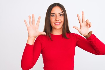 Young beautiful girl wearing red casual t-shirt standing over isolated white background showing and pointing up with fingers number eight while smiling confident and happy.