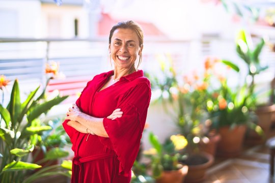 Middle age beautiful woman smiling happy and confident standing with a smile on face at terrace