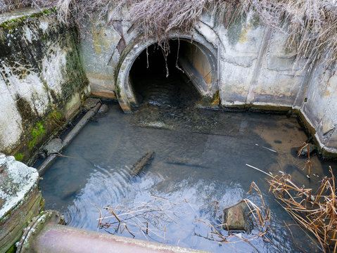 Flowing sewage water trough concrete tank, the water is transported to a small river, polluting the environment.