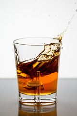 splashing whiskey in a glass on the background2