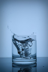 splashing water in a glass of whiskey on the background1