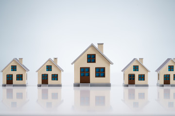 Small House Models Arranged In Row Over Table