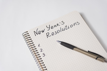 Phrase New Year's resolutions in the notebook and blank page, pen. - Powered by Adobe